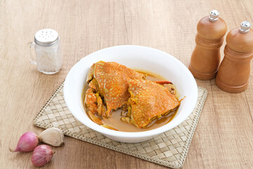 Kepiting Saus Padang (Crab with Padang Sauce), spicy and savory. Served in white bowl.
