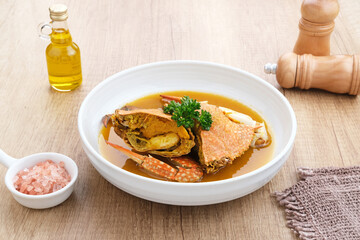 Kepiting Saus Padang (Crab with Padang Sauce), spicy and savory. Served in white bowl.
