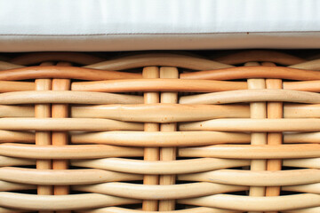 Close up wicker chair and white pad surface texture background. Utilization of rattan, especially as a raw material for furniture. traditional furniture.