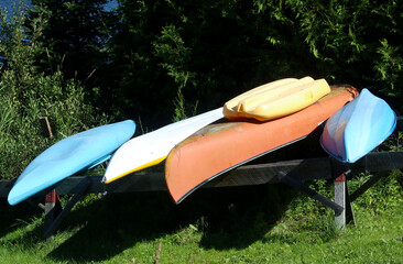 Canoes, kayaks and water craft on land at riverside