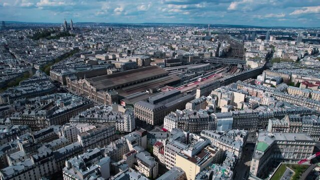 Paris Gare du Nord Train Station Building aerial orbiting with Paris city skyline on sunny day