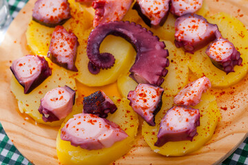 Traditional Galician fair dish of boiled octopus served with sliced cooked potatoes, smoked paprika and olive oil (Pulpo a la gallega)