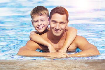 Happy family in swimming pool, having fun at pool party. childhood and parenting.