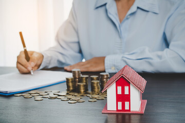 House model with stack coins, business hand is planning savings money of coins for buy home....