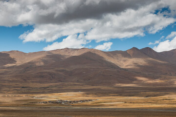 Fototapeta na wymiar Panoramic landscape in Tibet with a remote village and mountains on background
