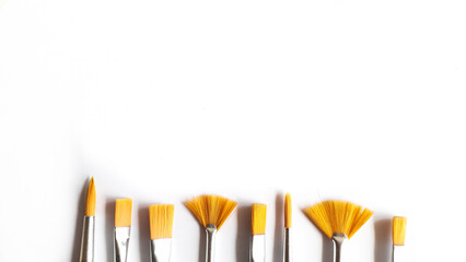 Top view of a variety of artist brushes on a white background with room for text. Creative postcard