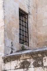 Fototapeta na wymiar window on historic stone wall. decorative security bars. 