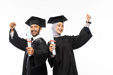 Two confident graduates wearing togas holding certificate while celebrating on isolated background