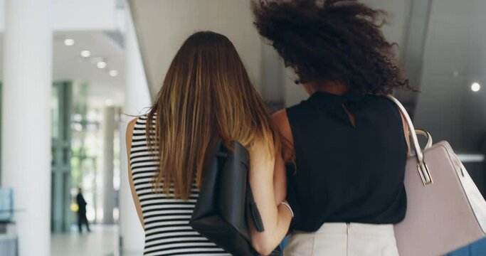 Fun, carefree and laughing women doing shopping, retail therapy and spending time together at the mall. Two young and stylish best friends, beauty shopper or customers looking back with a hair flip