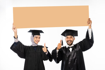 Couple of graduate student wearing toga holding cardboard blank space on isolated background