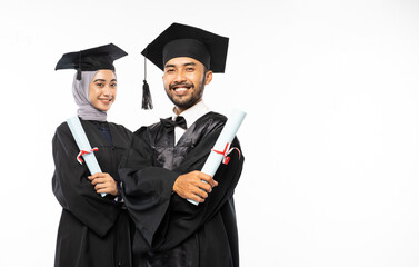 Smiling male and female graduate students wearing togas holding certificates standing on isolated background