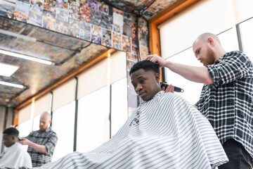 Man at the barbershop. Handsome black man getting a haircut in an African salon. Hairstyle. Haircut for adults