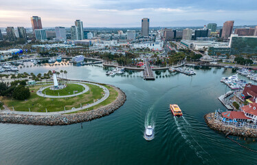 Downtown Long Beach CA at dusk with Rainbow Harbor in the foreground.
