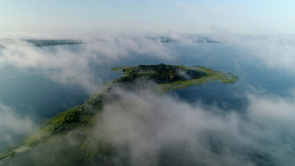 Flight in the clouds over the island of Lake Svityaz. Volyn, Ukraine, Shatsk National Park.