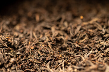 Large-leaved black tea in bulk on the table. Close-up of the surface texture
