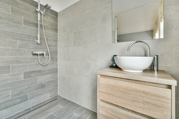 Modern black shower column in expensive open bathroom with gray tiled wall and window