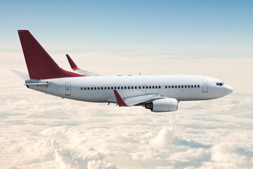 Passenger jet plane flies in the air above the clouds