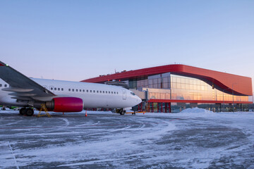 Passenger airplane parked at the terminal on the winter airport apron