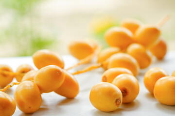 Fresh yellow dates on a white table. Selective focus.