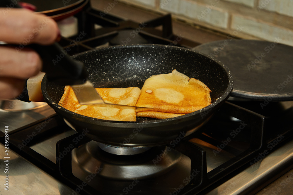 Wall mural Chef pan-frying Crepe Suzette pancakes with cognac and citrus sauce