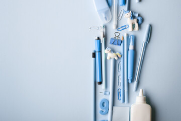 Background with various blue stationery lying in the center on a light blue background.