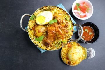 Chicken Biryani or murgh Pulao. Garnished with fried onion, mint leaves, and Boiled egg. Biryani is a famous Spicy nonvegetarian dish of India. Chicken cooked along with Basmati rice. Cucumber Raita.