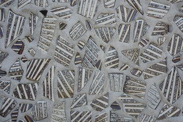 Unusual abstract texture and background fragments of ceramic tiles on cement wall.