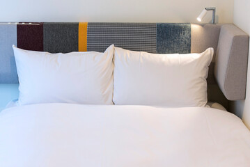 Front view of two white pillows on a made bed in hotel