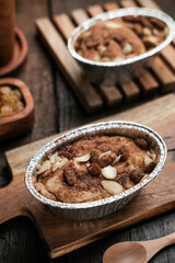 Klappertaart, Indonesian traditional dessert, from Manado. Coconut custard cake with raisin and almond topping, dusted with cinnamon powder, Dutch influenced dessert. 
