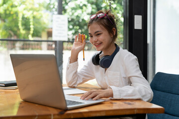 Online education, e-learning. young woman studying remotely, using a laptop, listening to online webinar at home