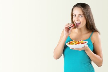 Sport, wellbeing and active lifestyle concept. Happy female athlete fitness girl holding salad