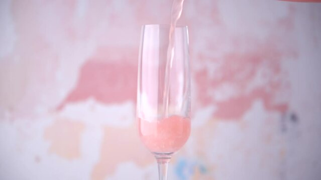 pouring pink drink into champagne glass