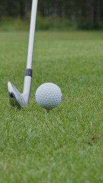 A close-up of a golf club hitting a ball while playing golf