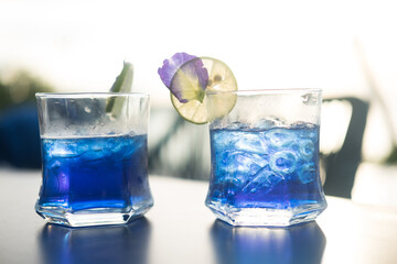 Two glass cups of butterfly pea iced tea. Summer refreshing drink.