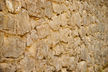 The wall is beige.Abstract background.The texture of a stone wall. A stone wall.