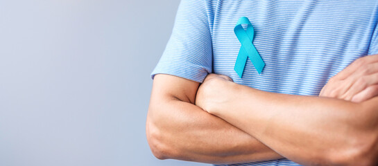 Blue November Prostate Cancer Awareness month, Man in blue shirt with hand holding Blue Ribbon for...