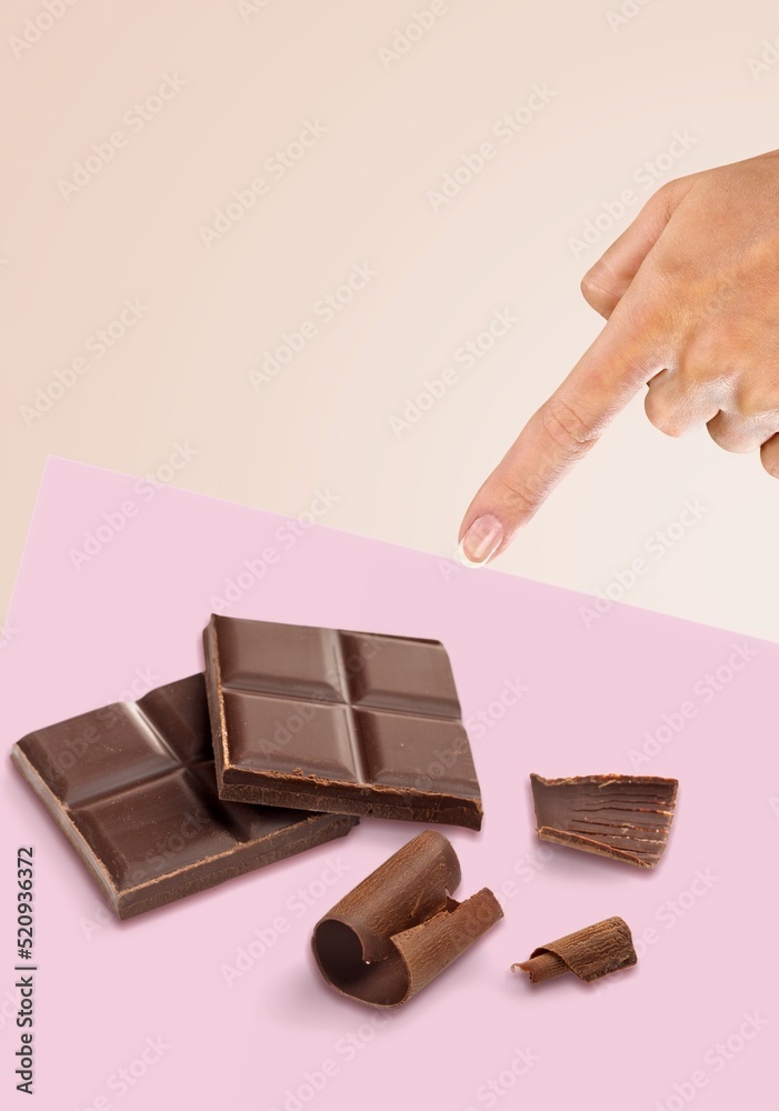 Canvas Prints Milk chocolate on a background. The girl's hand reaches for the chocolate. Creative chocolate photography.