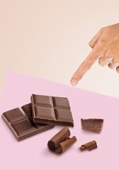 Milk chocolate on a background. The girl's hand reaches for the chocolate. Creative chocolate photography.