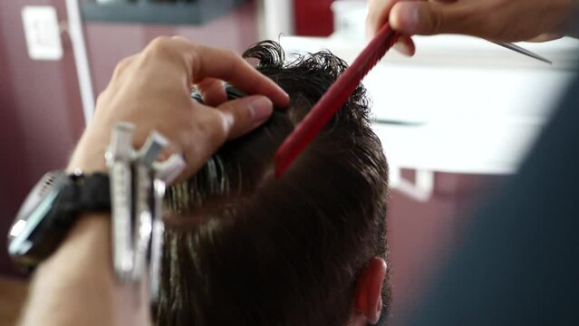 barber combs the client's hair before cutting it