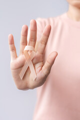 woman hand holding Peach Ribbon for September Uterine Cancer Awareness month. Healthcare and World...