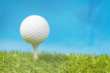 Golf ball with tee on green grass
