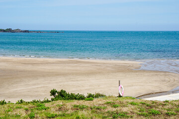 Taipei, Taiwan - July 20, 2022, calm beach by the sea, blue sea without people, sand, rocks, Lifebuoy
