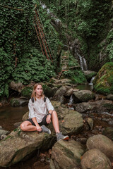 Naklejka na ściany i meble Travel. Girl travels through the mountains and waterfalls of wild nature. Unity, mental health, eco travel. Hiking in the mountains, van life vibes, travelling,good moments, digital detox
