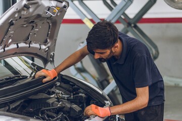 Fototapeta na wymiar Pakistani or Indian Mechanic repairing a car in garage