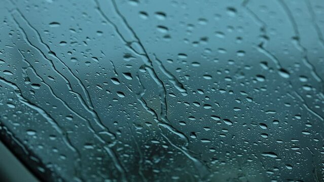 窓ガラスに降る雨の水滴　梅雨　イメージ