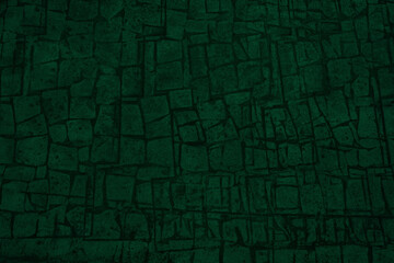 Black green background with space for design. Toned rough surface of an old stone wall. Close-up. Dark emerald green color. Backdrop. Solid. Grunge.