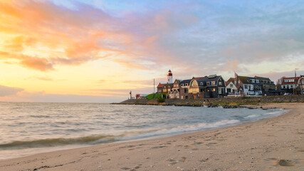 Urk Flevoland Netherlands sunset at the lighthouse and harbor of Urk Holland. Fishing village Urk....