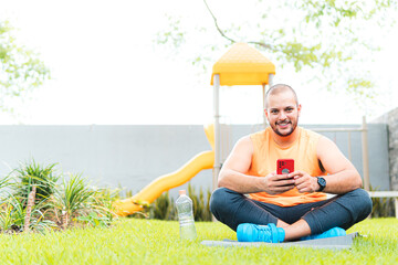 Young Latino man using cell phone in the park 