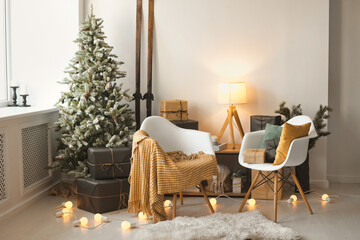 Cozy Christmas interior with natural xmas tree in Scandinavian style with two chairs, pillows and a...
