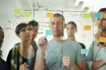 Group of creative business people brainstorm ideas on a glass board. Colleagues training, teamwork...